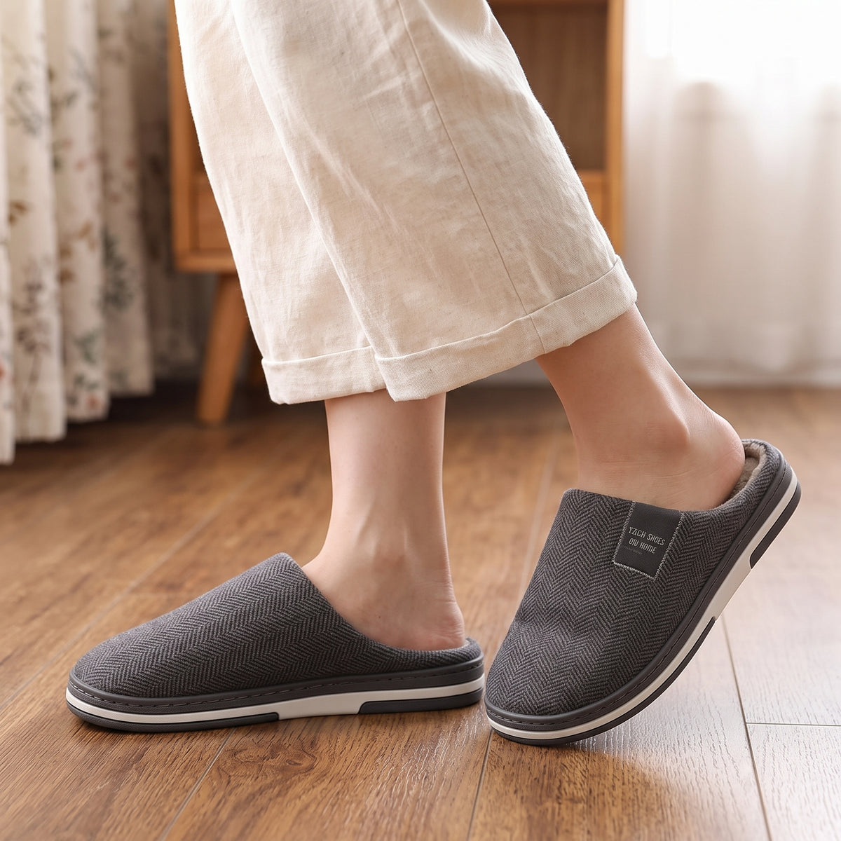 Chaussons femme Cosy gris anthracite à chevrons portés sur parquet
