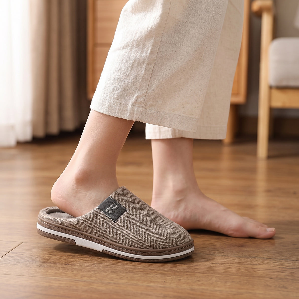 Chaussons femme Cosy marron à chevrons portés sur parquet