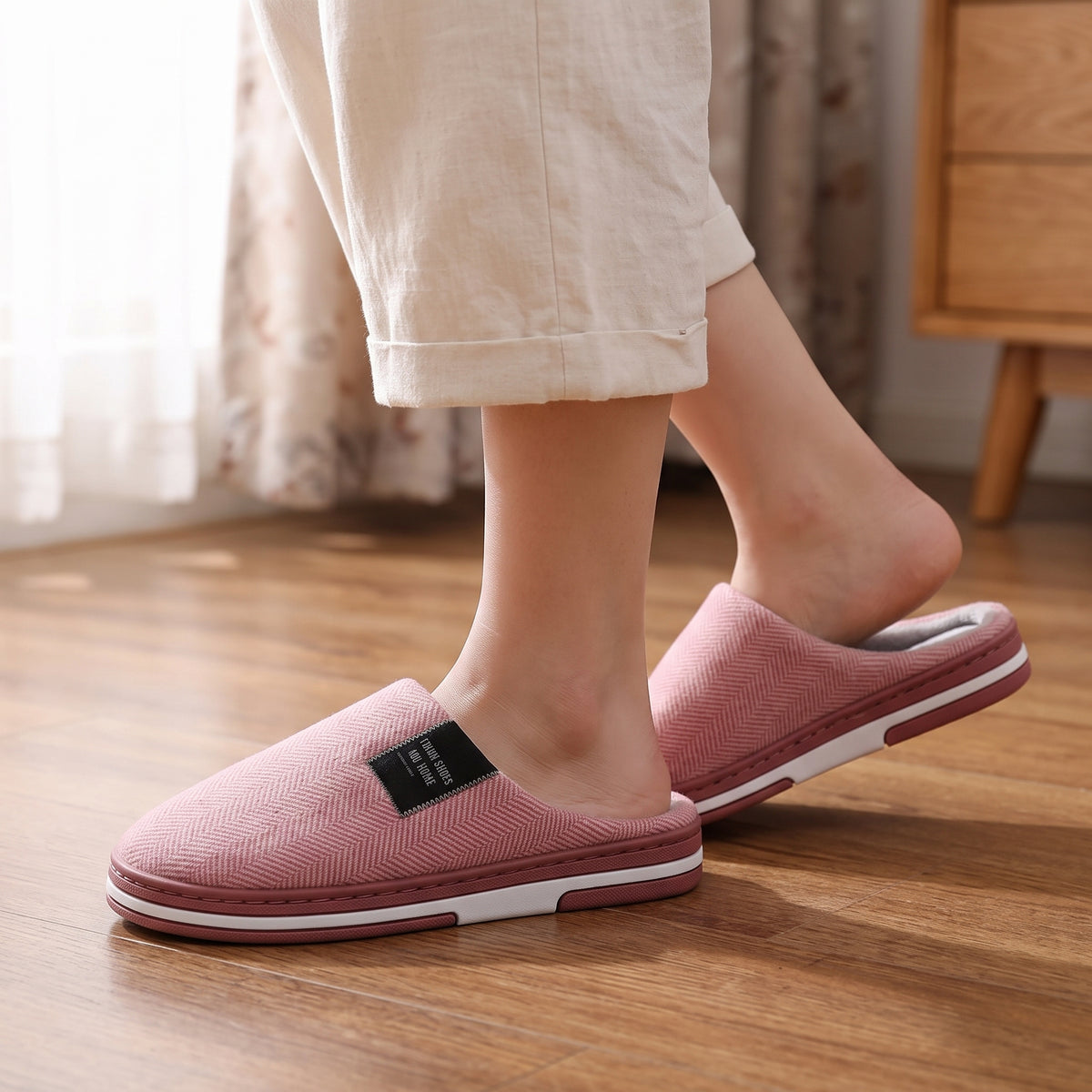 Chaussons femme Cosy rose à chevrons portés sur parquet